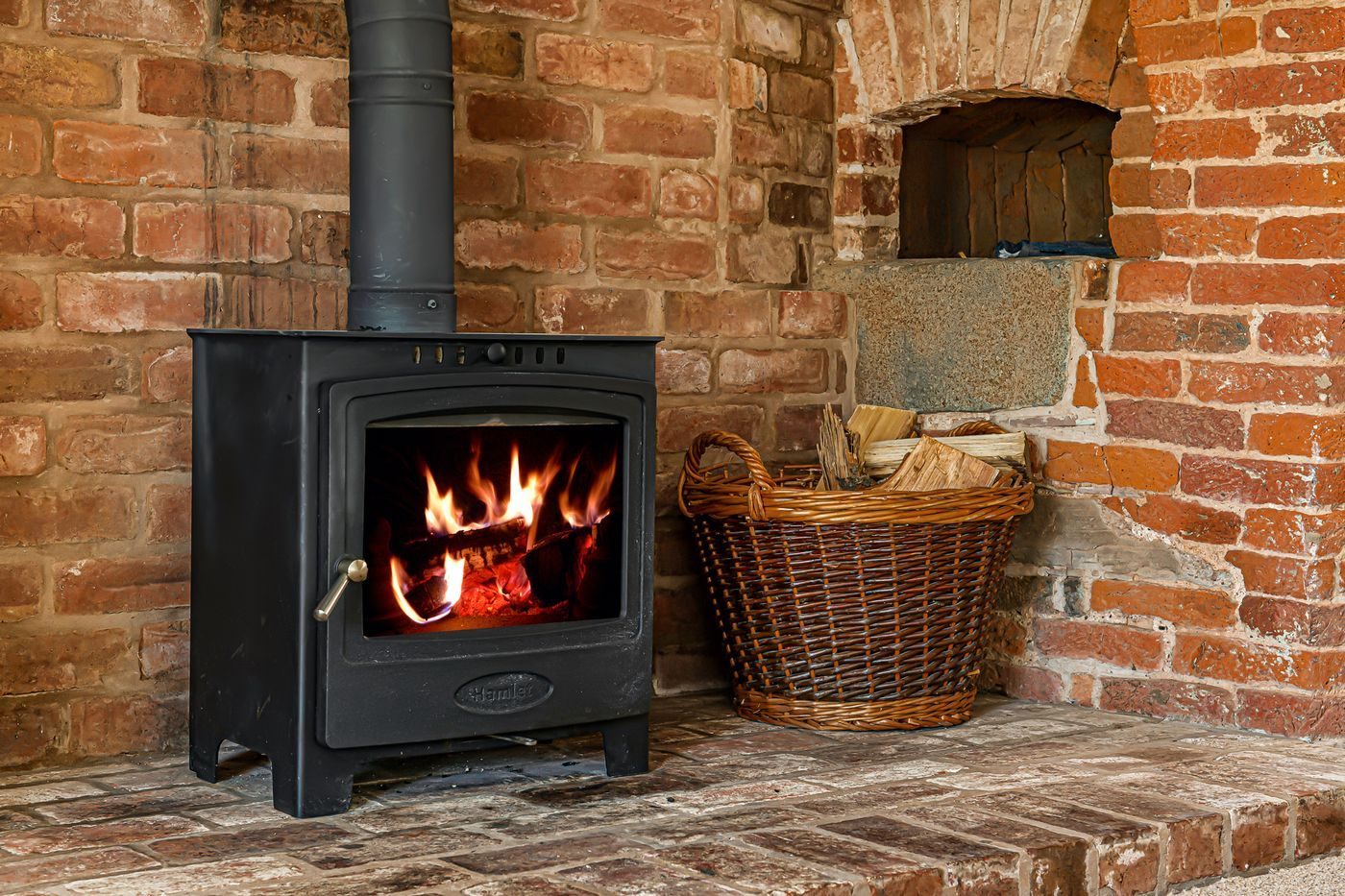 The fire roaring in the inglenook with a log basket alongside