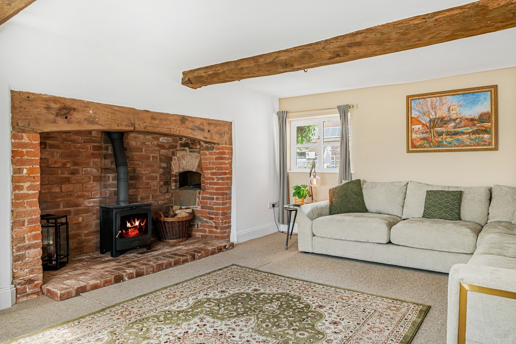 The front sitting room with the fire lit in the original brick inglenook